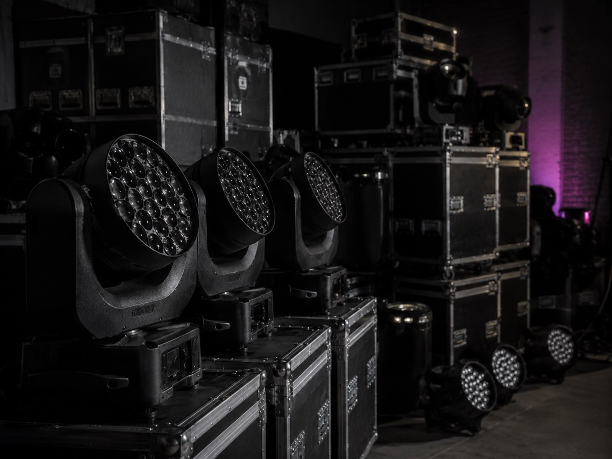Moving Lights und LED-Scheinwerfer auf Flightcases in einem abgedunkelten Lager